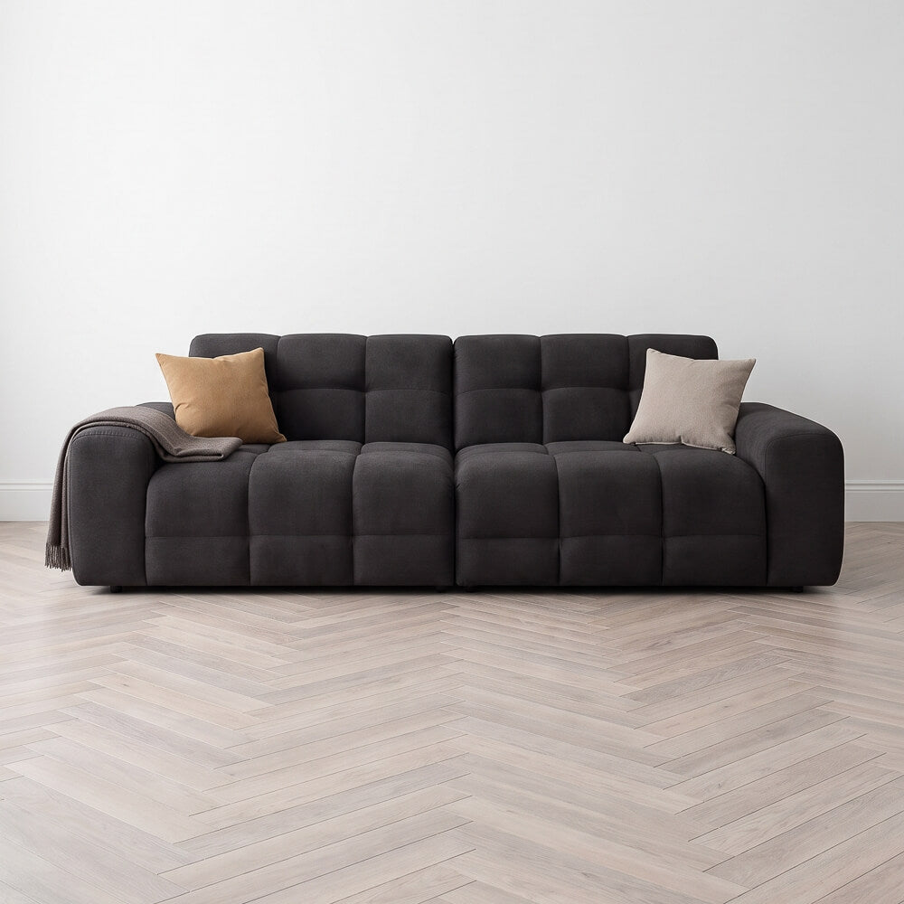 Black 4-seater tufted sofa with square arms and two accent throw pillows