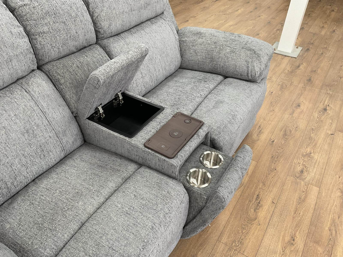 Grey power recliner sofa console with cupholders, tray, and storage opening in arm.