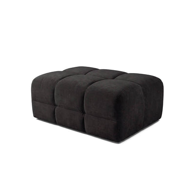 Upholstered dark ottoman footstool with tufted top panels and rounded corners