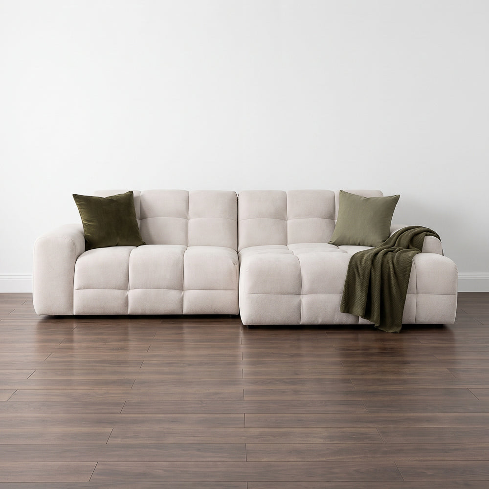 Light beige right corner sofa with tufted cushions, two accent pillows, and throw draped