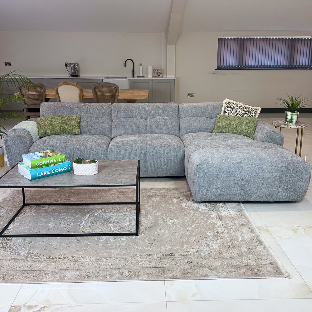 Light grey left-corner sofa with chaise-style section and green accent cushions