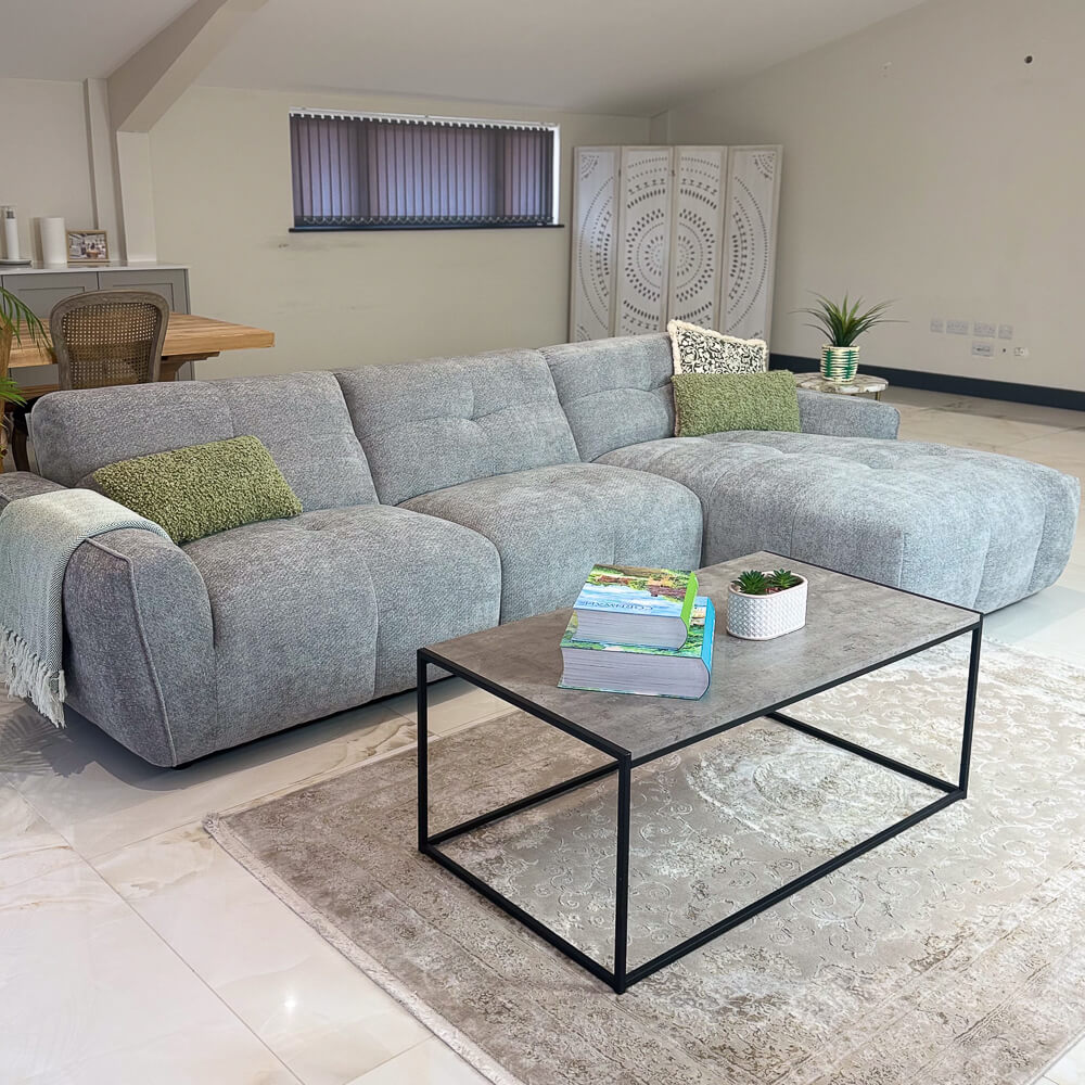 Grey left-corner sofa with padded sectional seats and rounded armrests