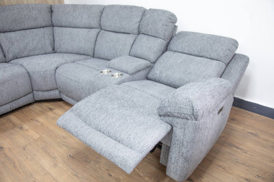 Grey recliner sofa with extended footrest and cushioned armrest