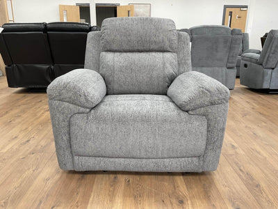 Grey upholstered recliner armchair with rounded seat, stitched back and arm pads.