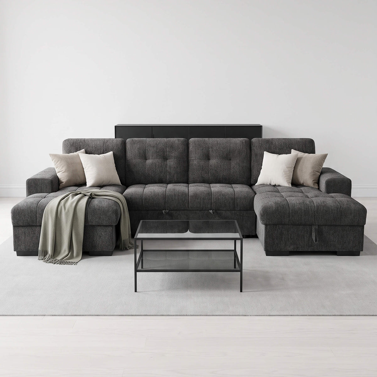 Grey U-shape sofa bed with tufted back, chaise ottoman, and two throw pillows