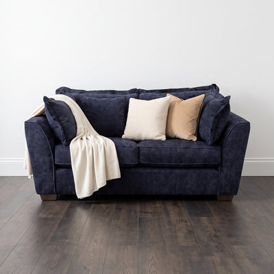 Dark blue 2-seater sofa with pillows and draped throw on the seat